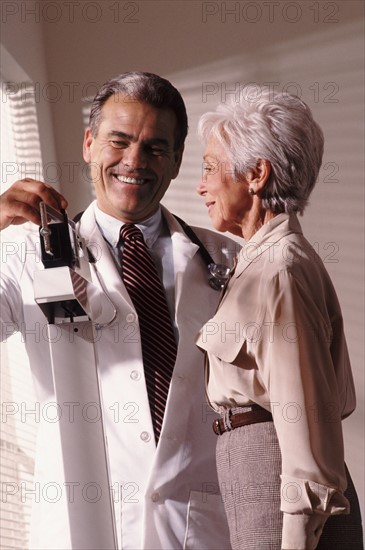 Doctor weighing senior patient. Photo : Rob Lewine