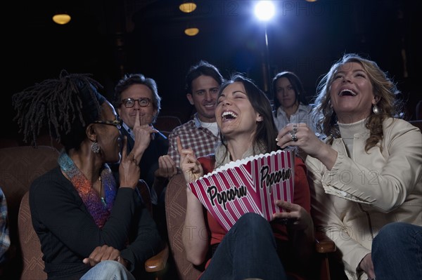 Women laughing loudly in movie theatre. Photo : Dan Bannister