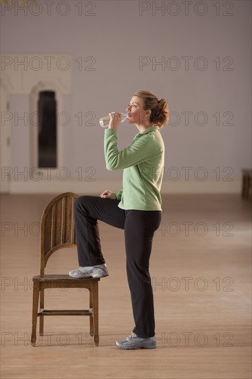 Woman drinking water after exercising. Photo : Dan Bannister