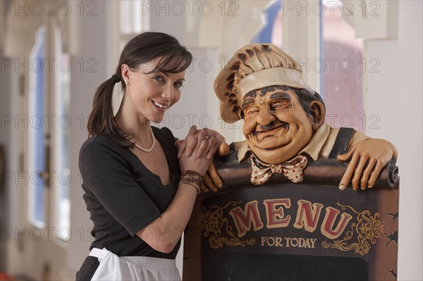 Waitress standing beside menu sign. Photo : Dan Bannister