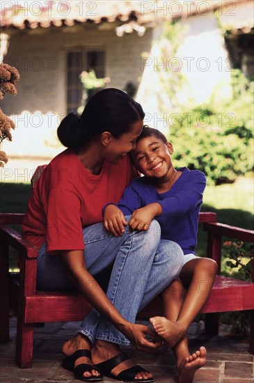 Mother and daughter sitting on bench in garden. Photo : Rob Lewine