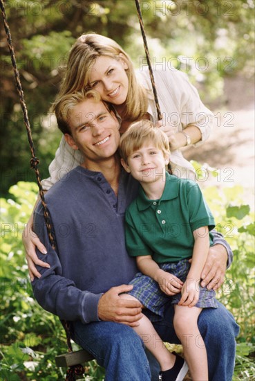 Parents and their young son posing by swing. Photo : Rob Lewine