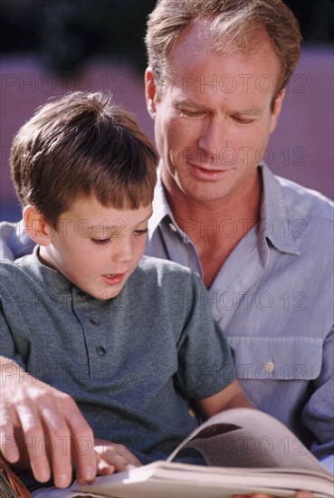 Father and son reading a book together. Photo : Rob Lewine