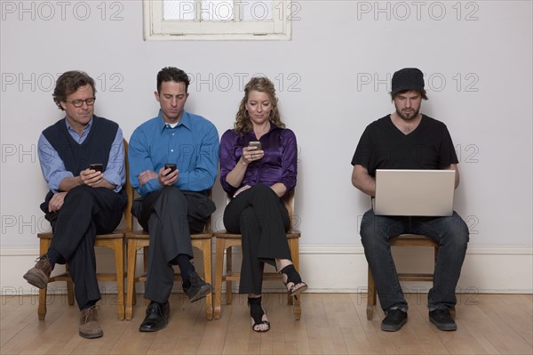 Four people sitting in a row. Photo : Dan Bannister