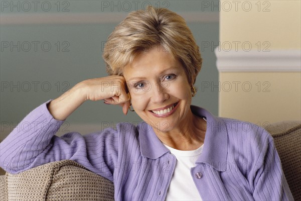 Pretty middle aged woman relaxing on couch. Photo : Rob Lewine