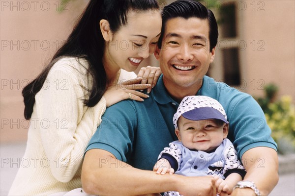 Happy parents sitting with their infant son. Photo : Rob Lewine