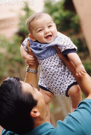 Happy father holding his infant son. Photo : Rob Lewine