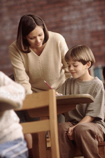 Teacher talking to elementary school student. Photo : Rob Lewine