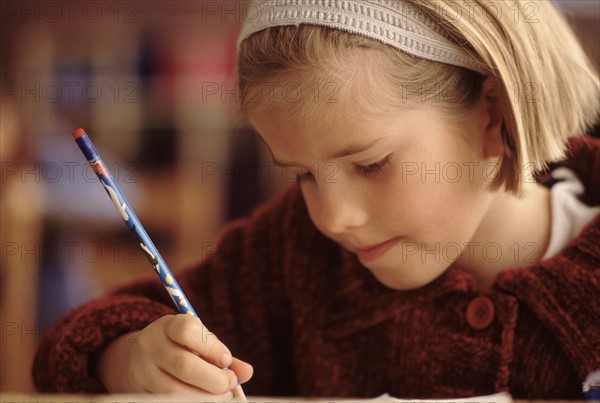 Elementary school student writing with a pencil. Photo : Rob Lewine