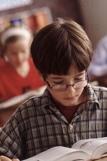 Elementary school student reading at his desk. Photo : Rob Lewine