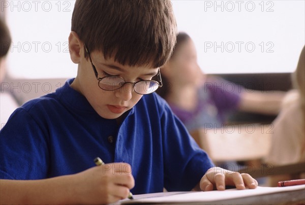 Elementary school student coloring with crayon. Photo : Rob Lewine