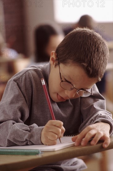 Elementary school student writing in his notebook. Photo : Rob Lewine