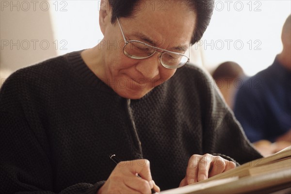 Senior student writing in notebook. Photo : Rob Lewine