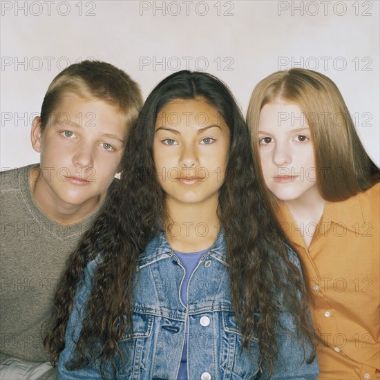 Three teenage friends sitting in a row. Photo : Rob Lewine