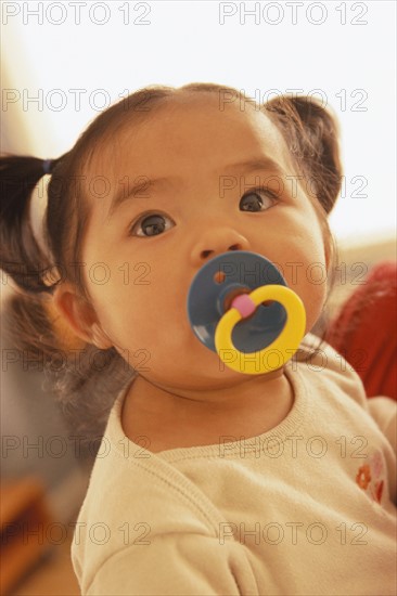 Infant with a pacifier in her mouth. Photo : Rob Lewine