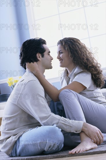 Affectionate couple sitting on floor in their home. Photo : Rob Lewine