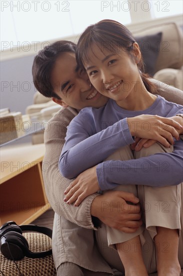 Happy couple sitting together on the floor in their home. Photo : Rob Lewine