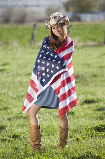 Beautiful cowgirl wrapped in American flag. Photo : Mike Kemp