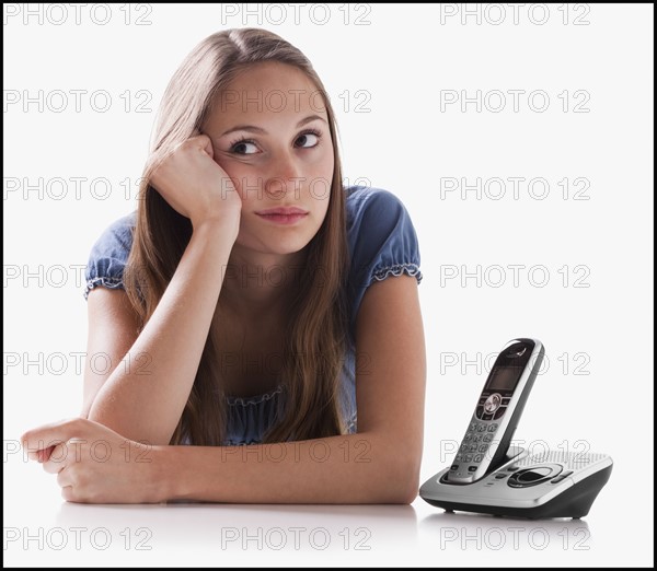 Bored woman waiting for the phone to ring. Photo : Mike Kemp