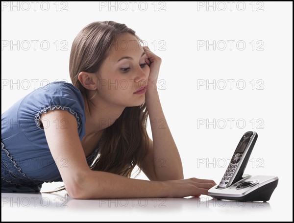 Bored woman waiting for the phone to ring. Photo : Mike Kemp