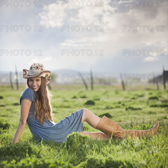 Cowgirl relaxing in field. Photo : Mike Kemp