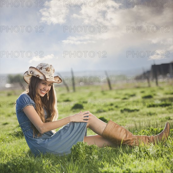 Cowgirl relaxing in field. Photo : Mike Kemp