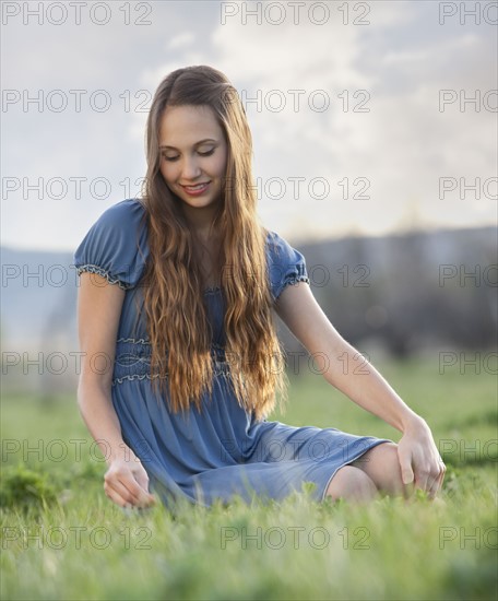 Beautiful long haired woman relaxing on the grass. Photo : Mike Kemp