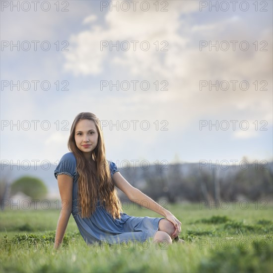 Beautiful long haired woman relaxing on the grass. Photo : Mike Kemp