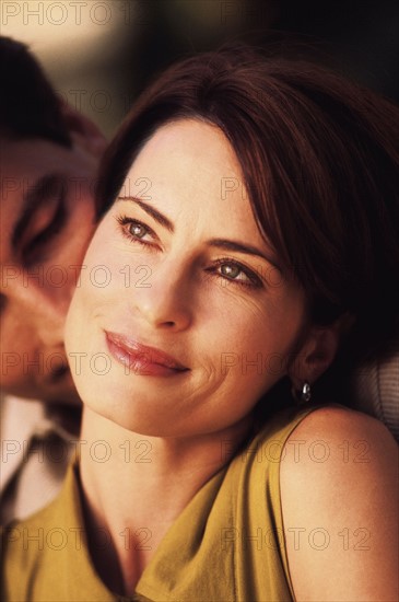 Smiling woman with affectionate man behind her. Photo : Rob Lewine