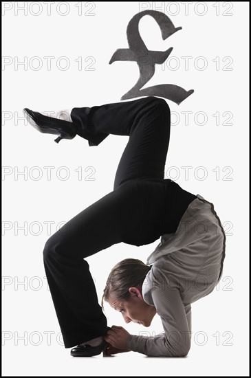 Pound symbol on top of contorted businesswoman. Photo : Mike Kemp