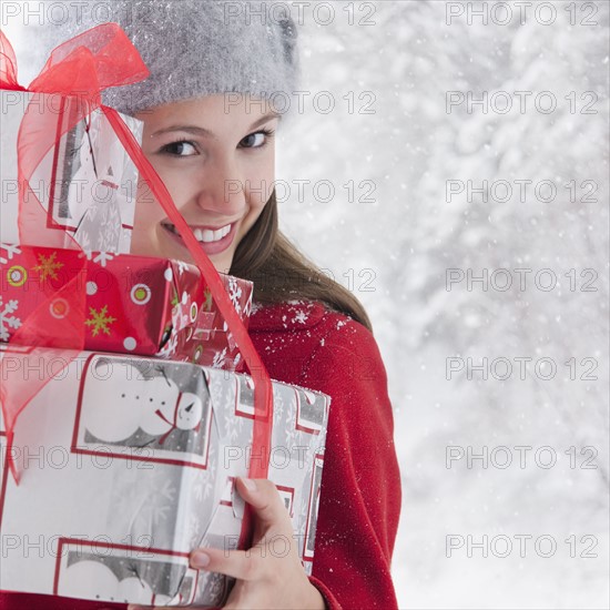 Woman holding stack of Christmas presents. Photo : Mike Kemp