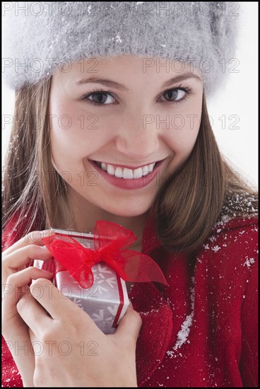 Woman holding small Christmas present. Photo : Mike Kemp