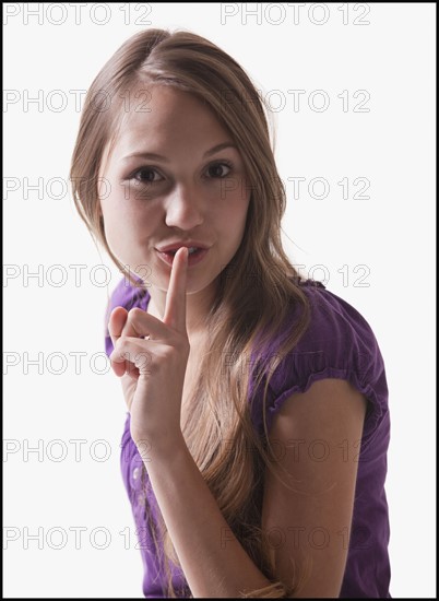 Woman holding her finger in front of her lips. Photo : Mike Kemp