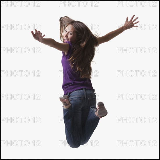 Teenage girl jumping for joy. Photo : Mike Kemp