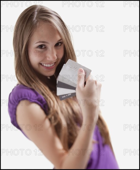 Smiling woman holding several credit cards. Photo : Mike Kemp