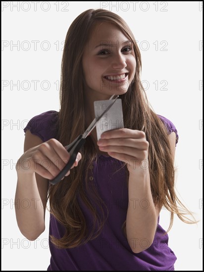 Woman cutting up a credit card. Photo : Mike Kemp