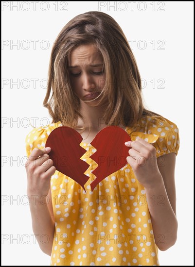 Teenage girl holding broken heart. Photo : Mike Kemp