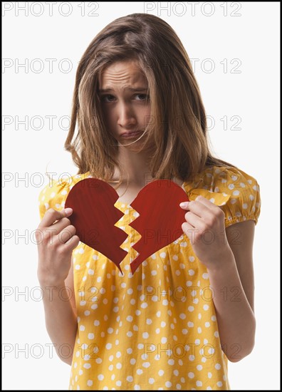 Teenage girl holding broken heart. Photo : Mike Kemp