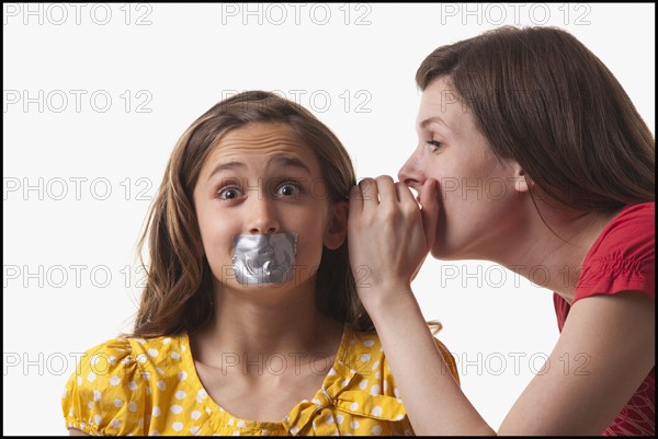 Woman whispering to a frightened girl. Photo : Mike Kemp