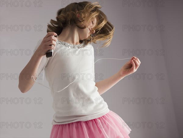 Young girl dancing on her bed. Photo : Mike Kemp