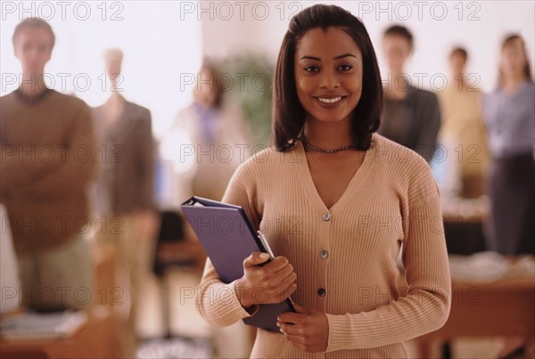 Pretty woman holding a binder. Photo : Rob Lewine