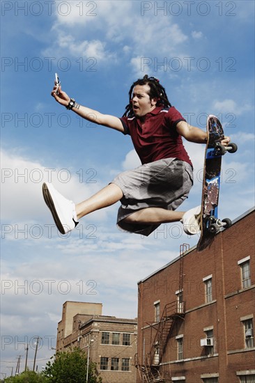 Teenage boy doing skateboard jump. Photo : Stewart Cohen