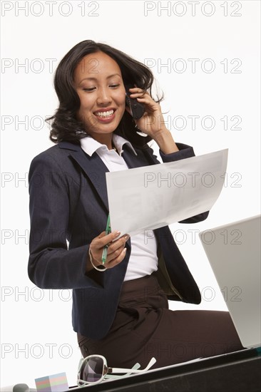 Businesswoman sitting on desk. Photo : K.Hatt