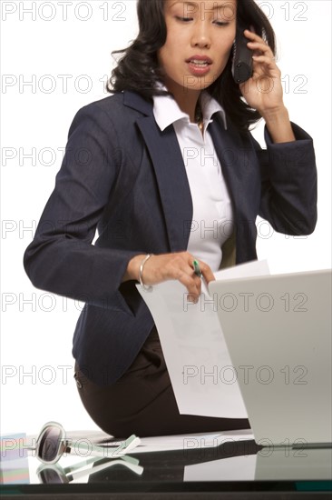 Businesswoman sitting on desk. Photo : K.Hatt