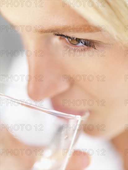 Woman drinking a glass of water. Photo : momentimages