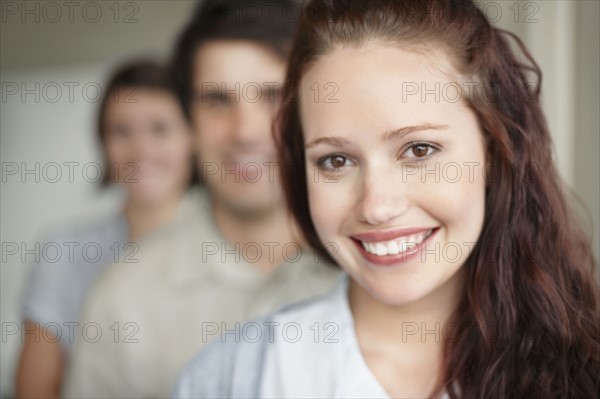 Three people standing in a row. Photo : momentimages