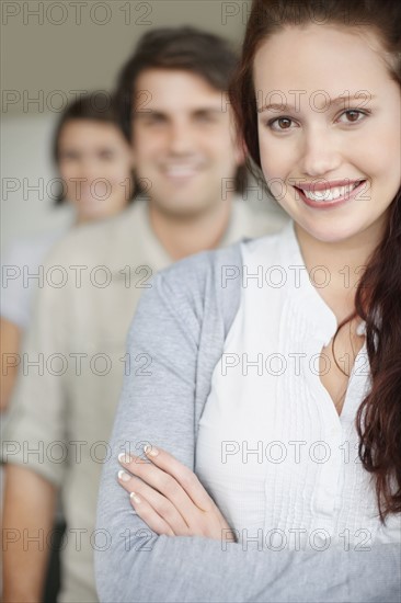 Three people standing in a row. Photo : momentimages