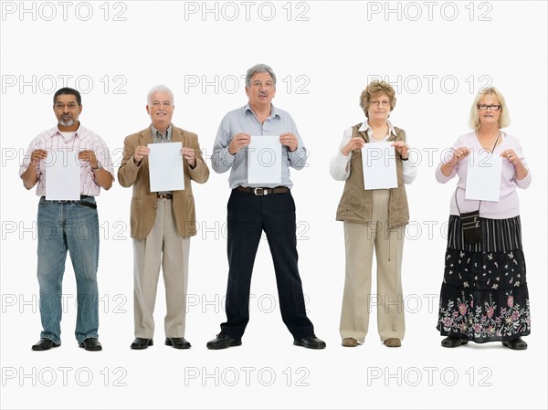 Group of people standing in a row holding papers. Photo : momentimages