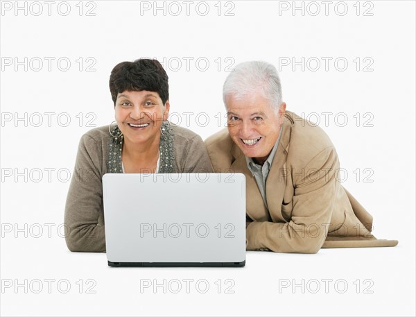 Retired couple looking at laptop together. Photo : momentimages