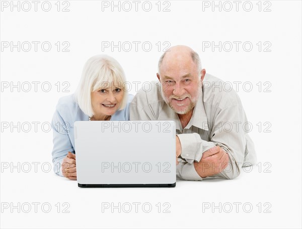 Retired couple looking at laptop together. Photo : momentimages